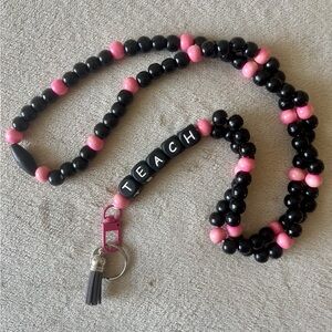 Black and pink lanyard with "TEACH" letters for educators